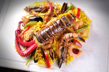 Traditional seafood paella with octopus, lobster, rice and shellfish