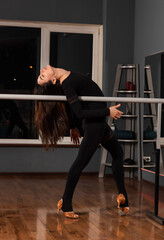 Girl in black dress are training in dance studio