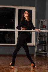Girl in black dress are training in dance studio