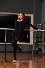 Girl in black dress are training in dance studio