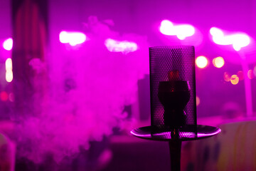 hookah in a bar at night against a neon background. steam cocktail. horizontal photo, space for text