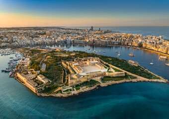 Aerial sunset view of Manoel island and fort, Sliema city on background. Gzira city, Malta