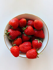 Strawberry. Berries in a white plate on a white table