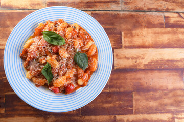 pasta in red sauce with parmesan cheese, tomato, basil, herbs, delicious food from Italian and French cuisine