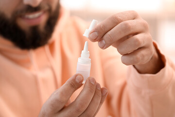 Handsome man with eye drops, closeup