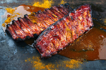 Obraz na płótnie Canvas Barbecue pork spare loin ribs St Louis cut with hot honey chili sauce served as close-up on a rustic black board