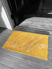 yellow welcome mat on black and white background