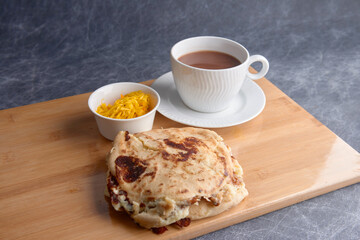 Salvadoran national dish pupusas stacked and served with curtido and hot chocolate