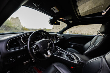 Interior of the muscle car. Black leather chairs.