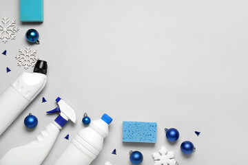 Cleaning supplies with Christmas decor on grey background