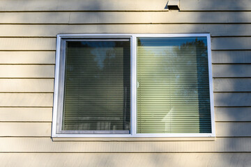 Exterior view of large window with closed blinds, residential building
