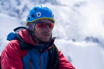 Man with sun glasses is climbing in the mountains.