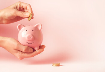 Girl holds a piggy bank in her hands.