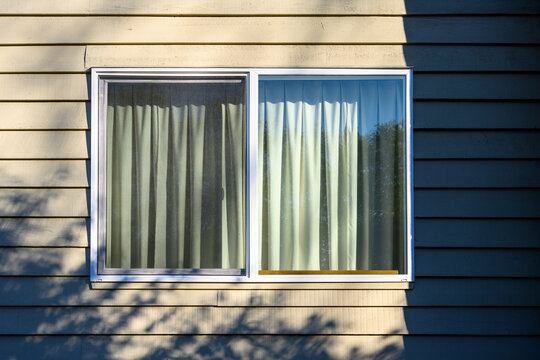 Fototapeta Exterior view of large window with closed curtains, residential building 