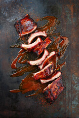 Barbecue pork spare loin ribs St Louis cut with hot honey chili sauce served as close-up on a...