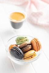Sweet macaron dessert. Colorful macarons in bowl on white table.