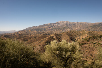 A view of spanish mountains taken from the hill above Arenas in Malaga, Andalusia. These rocky looking mountains are scattered with holiday homes and farms for crops like figs and olives