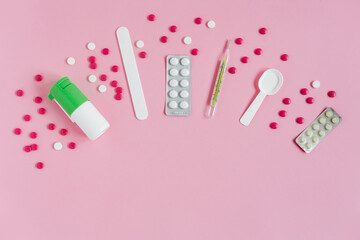Medical kit. Medicines for the treatment of virus, flu, covid, colds. Spray,pills,thermometer. Pink background. Top view. Copy space