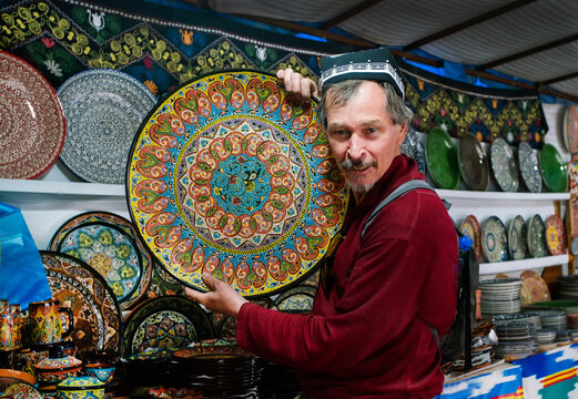 Tourist from Europe or Asia in Uzbekista on bazar (good  market ) with  Roofs of one-story houses