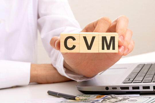 hand holds wooden cubes with inscription cvm, white background. Customer Value Management concept