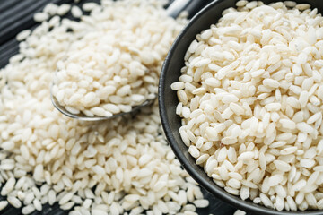 arborio rice for risotto on a black wooden background