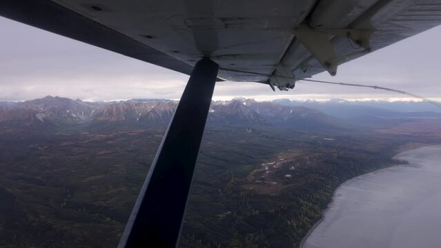 flying over alaska mountain range with a small bush float plane aviation window view