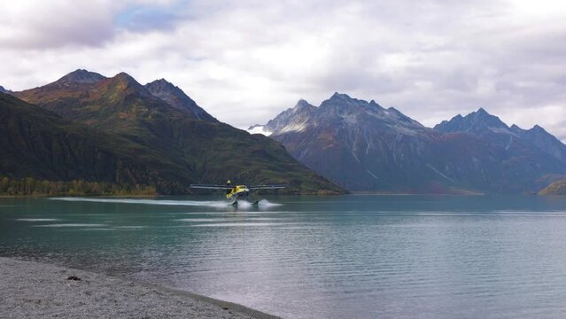 float plane lands on water in alaska in mountain range area near by homer cool avaition plane for travel etc