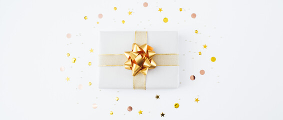 Banner made of Christmas present and gifts and golden confetti on white background. Merry christmas, New Year holiday concept. Flat lay, top view, copy space.