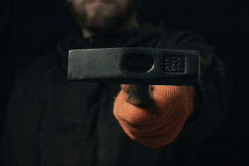 A man hand holds a hammer isolated on a black background