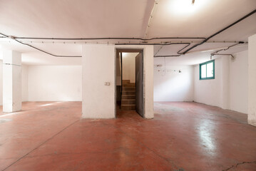 An empty single-family home garage with a central stairway upstairs