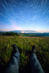Night view of High Tatras from Panska Hola, Low Tatras National Park Slovakia.Green meadows and mountains in the background. Sitting under the night sky. Startrails © Filip