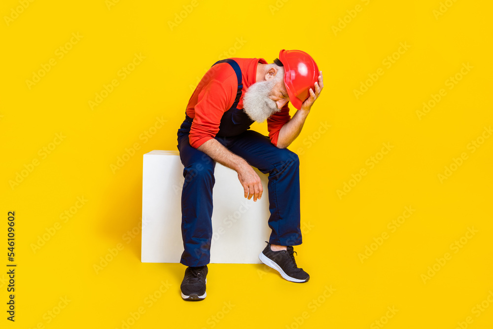 Wall mural photo of stressed jobless age man wear overall uniform red hard hat feeling tired isolated yellow co