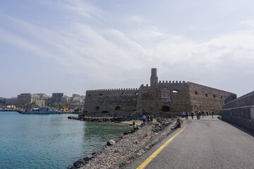 Fototapeta na wymiar Heraklion, Crete, Greece: Tourists explore the Castello a Mare (Koules) Fortress, built by the Republic of Venice in the 16th Century, at the entrance to the old port of Heraklion.