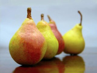 pears, ripe pears on a dark wooden background, laid out one after the other with the focus on the first one. fruits