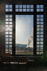 Old Faithful erupts, as seen from the Old Faithful Lodge windows