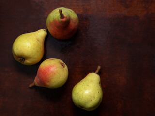 pears scattered on a dark wooden background. ripe pears, fruits