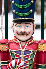 A close up of a toy soldier holding candy cane.
