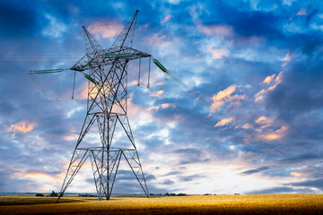 Transmission tower standing tall at sunrise on a prairies landscape in Rocky View County Alberta Canada.