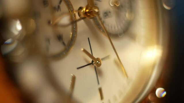 Clock hands in motion on the dial clock face of a gilded gold plated mechanical quartz glamorous chronometer watch close-up macro. Running of time and life 