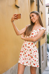 Blonde girl smiling while she takes a self portrait.