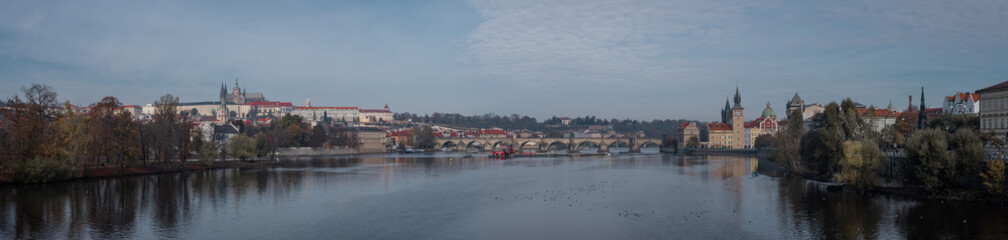 Famous charles bridge or karlow bridge in the center of Prague, spanning over Vltava river on autumn day with Hradcani seen in the background.