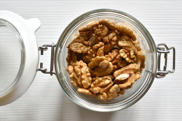 Walnuts top view, glass jar on white background