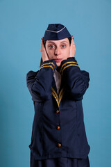 Flight attendant covering ears with hands, showing hear no evil gesture. Airplane stewardess looking at camera front view, no listen sign, three wise monkeys wisdom concept