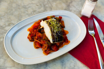 Popular dish of Spanish cuisine is Bacala, made from fish with vegetables and decorated with...