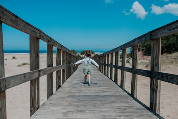 Boy playing on a wooden bridge