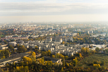 Aerial view of autumn morning in Warsaw. Grey buildings and trees with foggy blurred horizon line. Cloudy sky. Horizontal shot. High quality photo