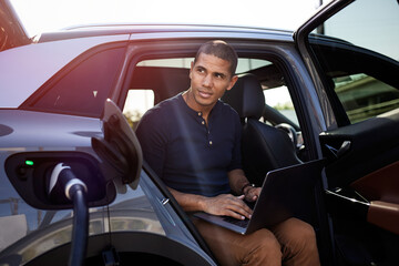 Contemplative man with laptop sitting in car
