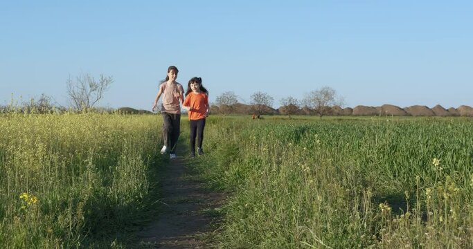 Have fun with your sister in nature. Happy little girls running together in nature on tro.