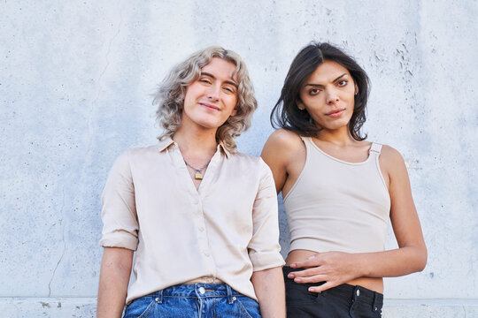 people smile gently posing in front of concrete wall in shade