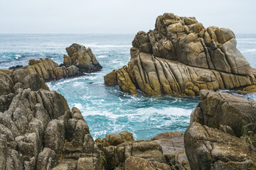 Waves splash on rocks on sea shore, Monterey Bay, CA
